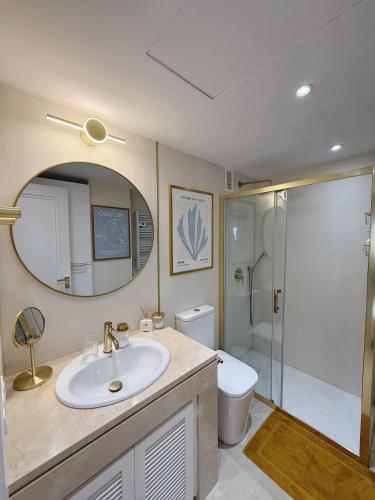 a bathroom with a sink and a toilet and a mirror at PlayaDuquesa Apartment SEAVIEW in Manilva
