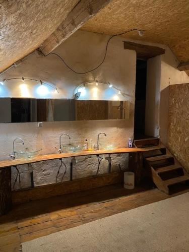 une cuisine avec deux éviers et un comptoir avec lumières dans l'établissement Château de Gressoux, à Auxon