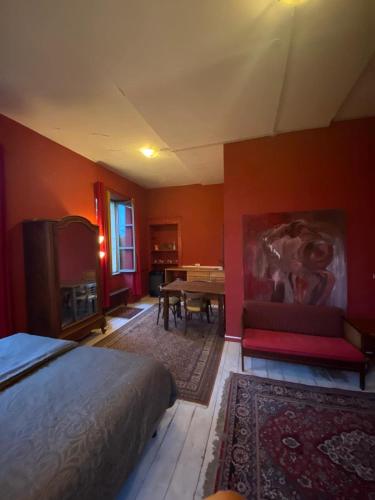 - une chambre avec des murs orange, un lit et une table dans l'établissement Château de Gressoux, à Auxon