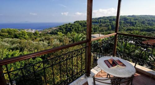 a balcony with a table and chairs and the ocean at Vatellis Villas in Patitiri