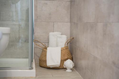 a bathroom with a basket of towels and a shower at Blumarine Residence Club in Ostuni
