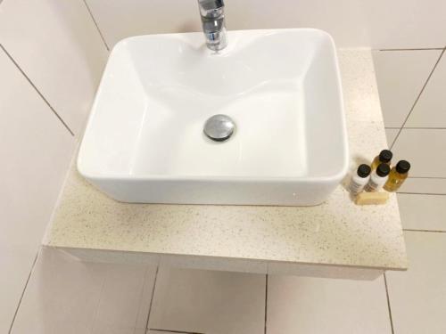 a white sink sitting on a counter in a bathroom at Résidences Les Hauts de l'Indenié in Abidjan