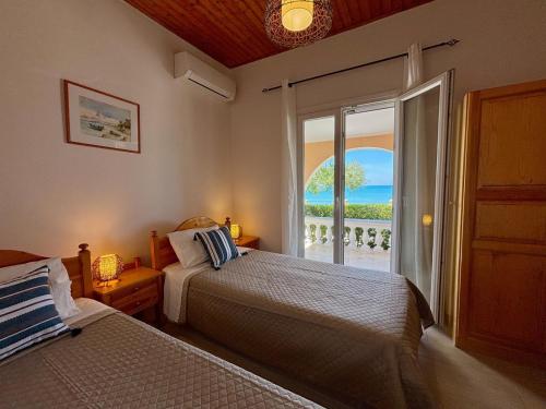 a bedroom with two beds and a view of the ocean at Villa Antonia- Acharavi beach in Acharavi