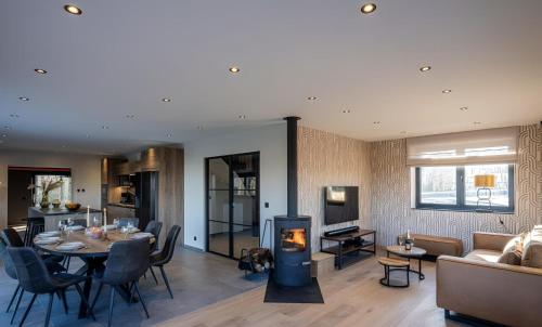 a living room with a table and a fireplace at Au bout du bois in Jalhay