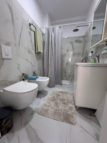 a white bathroom with a toilet and a sink at Villa Sara in Golem