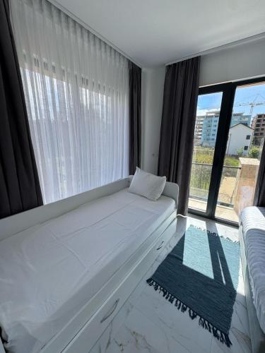 a white bed in a room with a large window at Villa Sara in Golem