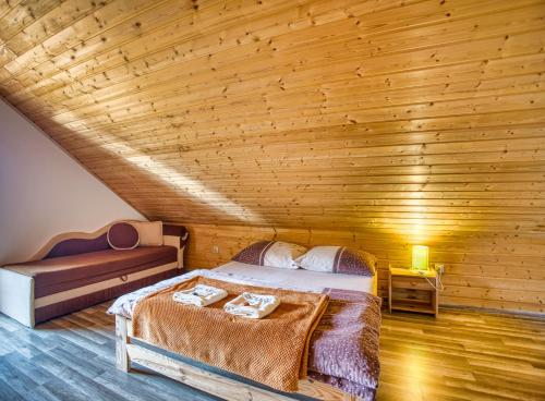 a bedroom with a bed and a wooden ceiling at Domki Pokoje Fil in Solina
