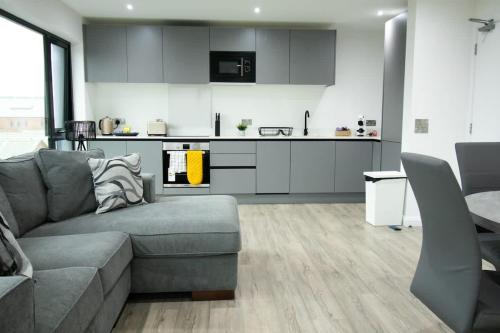 a living room with a couch and a kitchen at Beautiful 3Bed Flat in Belfast City Centre in Belfast