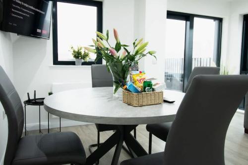 a dining room table with a basket of flowers on it at Beautiful 3Bed Flat in Belfast City Centre in Belfast