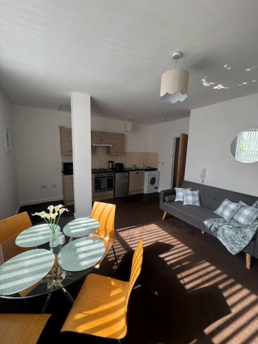 a living room with a table and a couch at Chic Trafford Apartment, Private Underground Parking, Fast Wi-Fi, Self Check-in Anytime, 5 mins to Old Trafford Stadium in Manchester