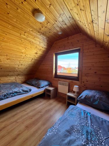 a attic room with two beds and a window at Magija Bałtyku in Sarbinowo