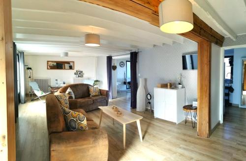 un salon avec un canapé et une table dans l'établissement Gîte de la falaise, à Saint-Valery-sur-Somme