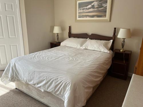 a bedroom with a large white bed with two lamps at Palmgrove Bed & Breakfast in Listowel