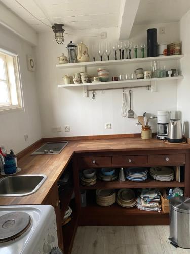 a kitchen with a sink and a counter with dishes at Tinyhouse Thorøhuse in Assens