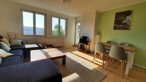 un salon avec un canapé et une table dans l'établissement Retour de plage, balcon, 2 chambres, à Dunkerque