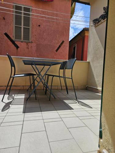a table and chairs sitting on a balcony at Casa Alessio, luminosa, centrale, ad un passo dal mare in Varazze