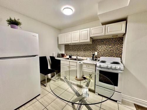 una cucina con frigorifero bianco e tavolo in vetro di Comfortable place In An Amazing Location a Toronto