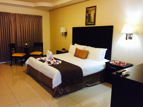 a hotel room with a large bed in a room at Hotel y Restaurante El Guarco in Cartago