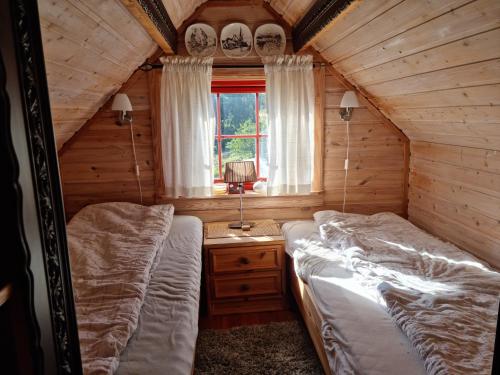 Un dormitorio con dos camas en una cabaña de madera. en Flott hytte på Bygland, en Bygland