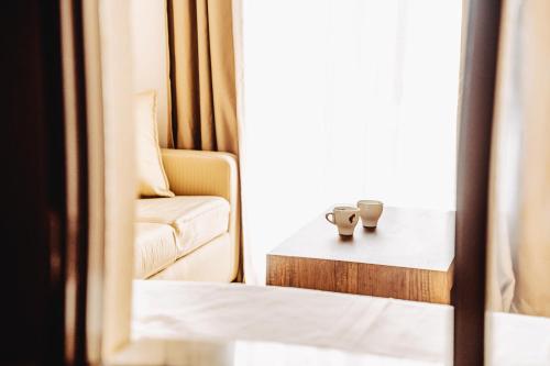 a room with a couch and two cups on a table at The Lume Boutique Hotel & Restaurant & Spa in Bodrum City