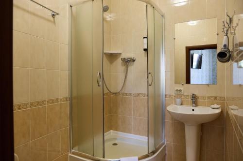 a bathroom with a shower and a sink at Hotel Plazma in Lviv
