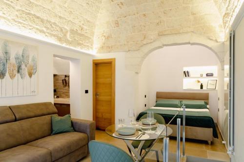 a living room with a couch and a bed at La Maison - Private wellness in Ostuni