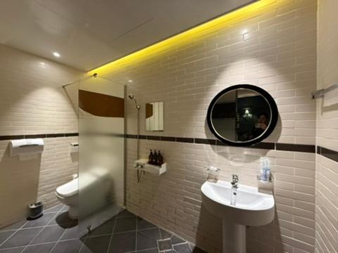 a bathroom with a sink and a toilet and a mirror at Venice Hotel in Ulsan