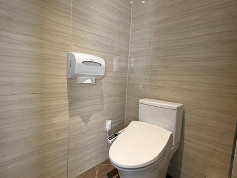 a bathroom with a toilet and a paper dispenser at Venice Hotel in Ulsan