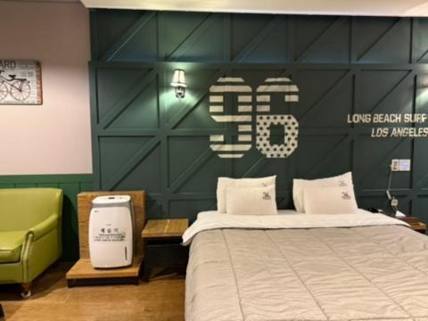 a bedroom with a bed and a green wall at Venice Hotel in Ulsan