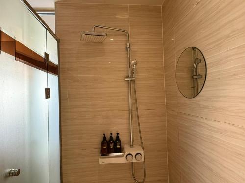 a bathroom with a shower with bottles on a shelf at Venice Hotel in Ulsan