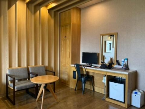 a room with a desk with a computer and chairs at Venice Hotel in Ulsan