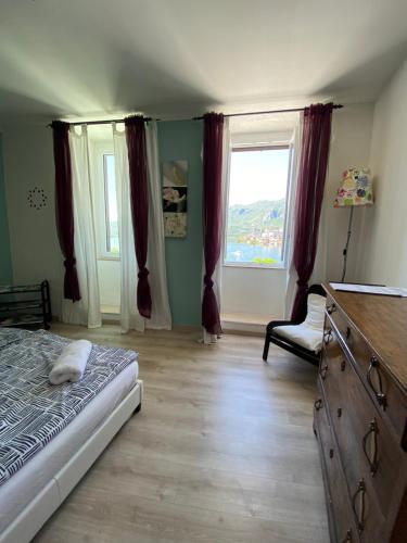 ein Schlafzimmer mit einem Bett, einer Kommode und einem Fenster in der Unterkunft Lakeside apartment in Orta San Giulio