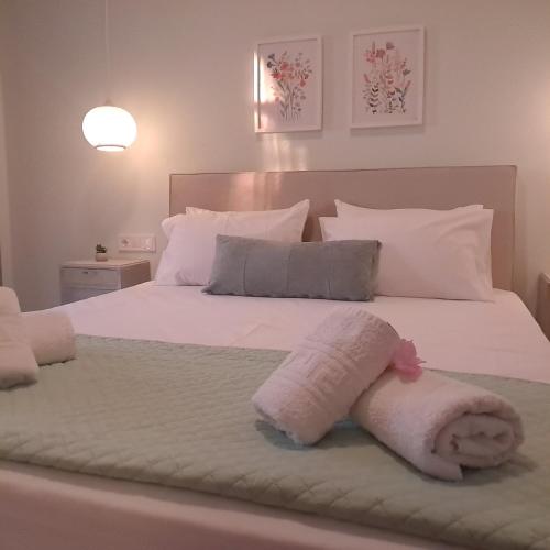 a bedroom with a white bed with a towel on it at Olga's Garden Apartments in Almiros Beach