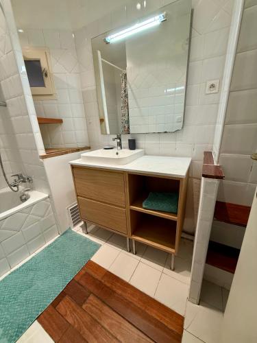 une salle de bain avec un lavabo et un miroir dans l'établissement Duplex T3 front de mer, à La Seyne-sur-Mer