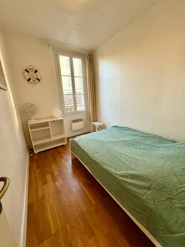 une chambre avec un lit vert et une fenêtre dans l'établissement Duplex T3 front de mer, à La Seyne-sur-Mer