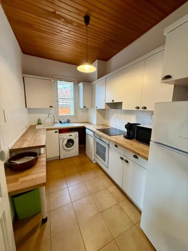 une cuisine avec des appareils blancs et un plafond en bois dans l'établissement Duplex T3 front de mer, à La Seyne-sur-Mer