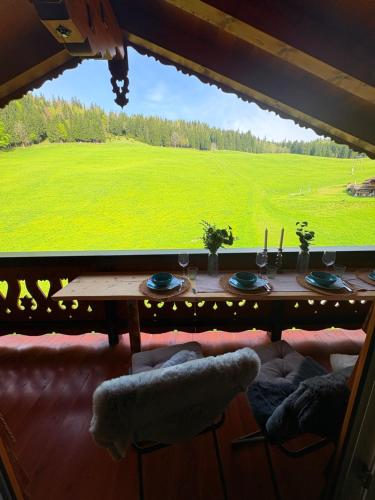 a dining room table with a view of a green field at Ferienwohnung Datzmannlehen mit traumhaften Bergblick und Sauna in Ramsau