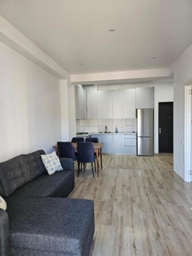 a living room with a couch and a kitchen at Cozy & Modern Studio in Tbilisi City