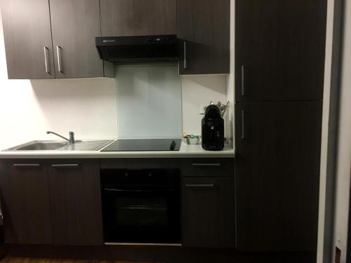 a kitchen with a sink and a stove top oven at Joli Appartement T2 in Saint-Jean-Pied-de-Port
