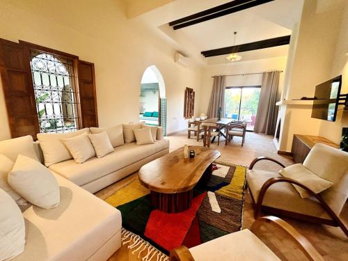 a living room with a white couch and a table at Villa Dar Ambre in Marrakech