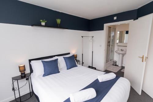 a bedroom with a large white bed with blue walls at Boutique 2-Bed Apartment in Wolverhampton Centre in Wolverhampton