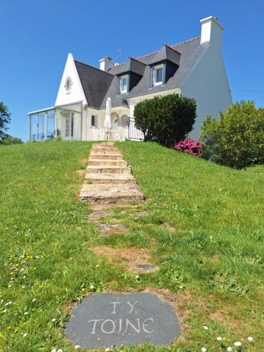 une maison avec un panneau indiquant « essayer de tourner » dans l'herbe dans l'établissement Tytoine, à Crozon