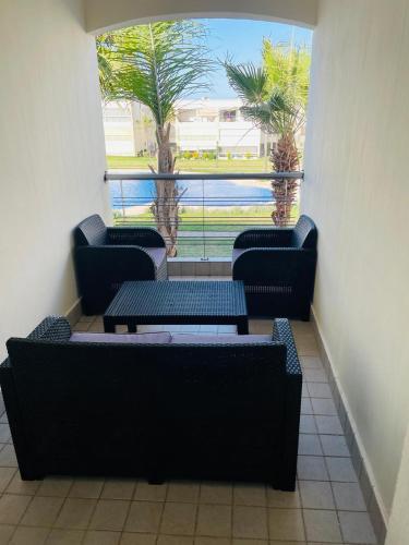 a room with four chairs and tables and a window at Ola blanca 1 enjoy in Sidi Rahal