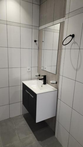 a white bathroom with a sink and a mirror at Kalinin 245 in Dilijan