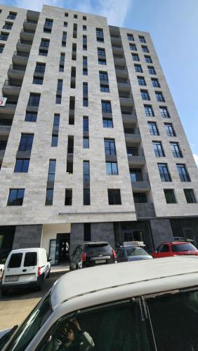 un coche aparcado delante de un edificio alto en Kalinin 245, en Dilijan