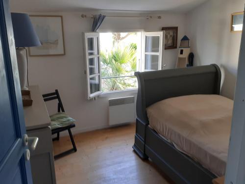 une chambre avec un lit et une fenêtre dans l'établissement Maison de famille, à Saint-Clément-des-Baleines