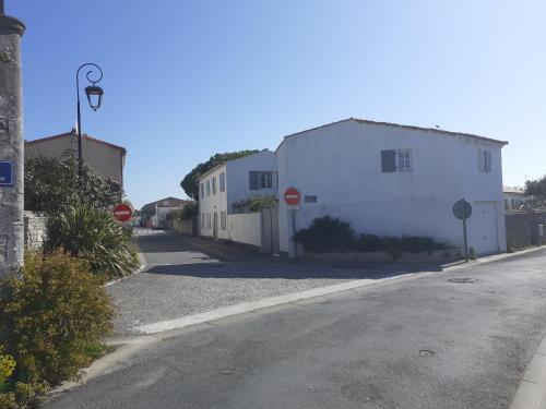 une rue vide avec des bâtiments blancs et un panneau d'arrêt dans l'établissement Maison de famille, à Saint-Clément-des-Baleines