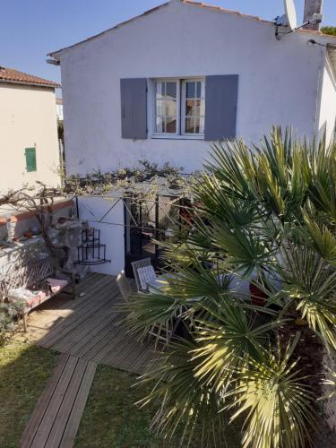 une maison avec une terrasse en bois devant elle dans l'établissement Maison de famille, à Saint-Clément-des-Baleines