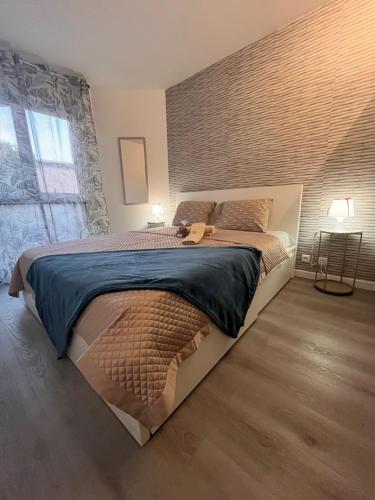 une chambre avec un grand lit avec un mur de briques dans l'établissement Eden suite, Évry-Courcouronnes