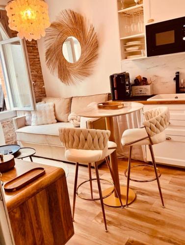 un salon avec un canapé, une table et des chaises dans l'établissement Le Petit Hôtel de Laura Cosy Parking & Netflix, à Toulouse